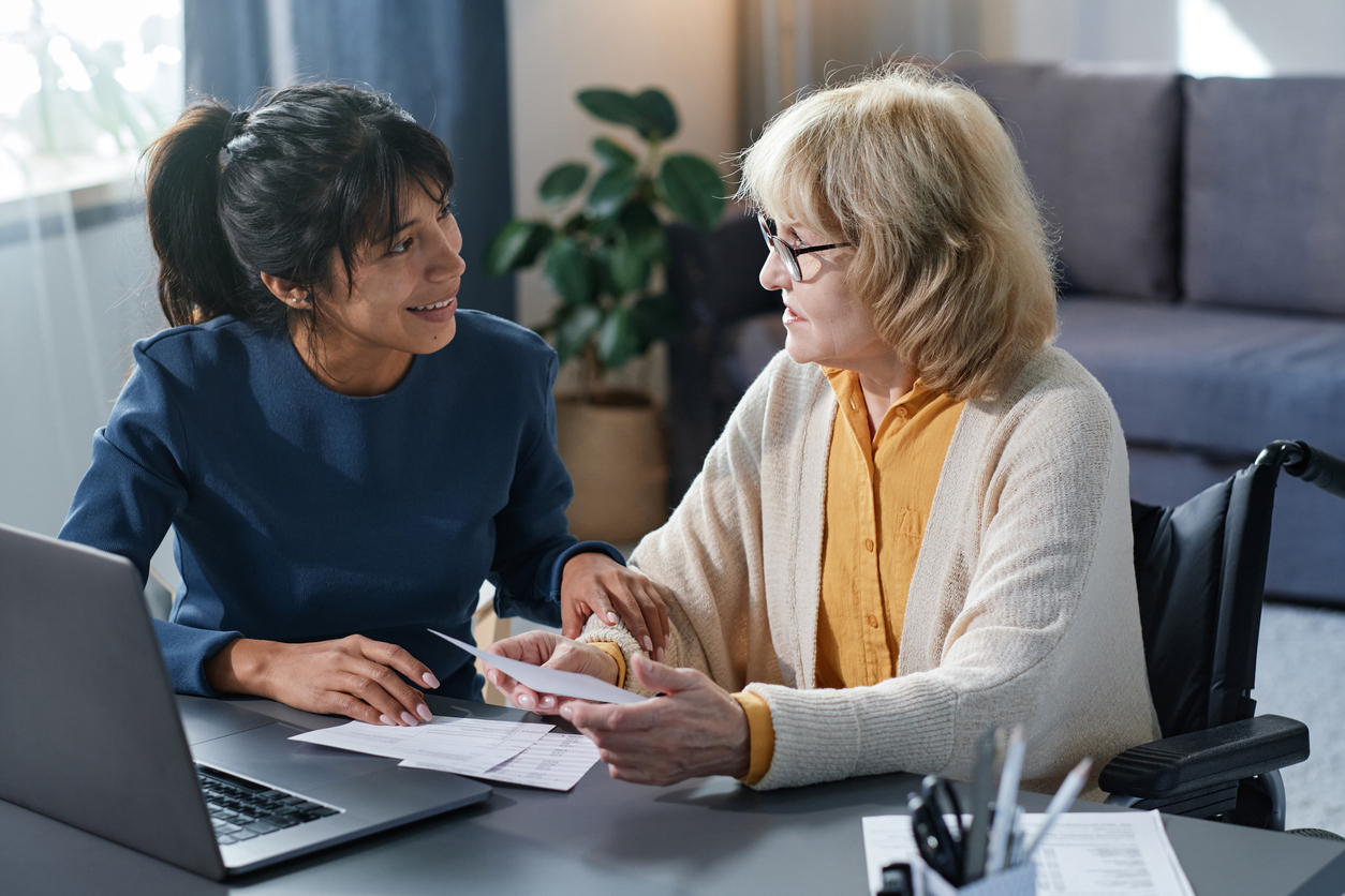 Volunteer helping to senior woman with bills